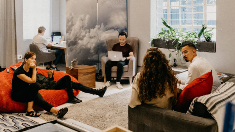 Fintech team relaxing on chairs and beanbags in in lunch room