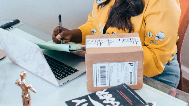 a woman at a desk filling in forms for her side hustle ideas