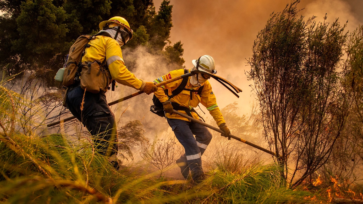two firefighters from Volunteer Wildfire Services tackling a wildland fire.