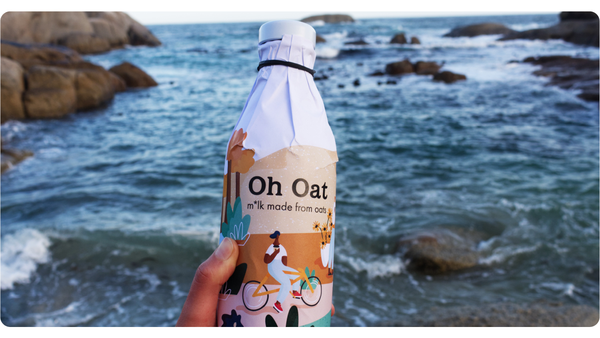 image of a hand holding a bottle of Oh Oat's oat milk