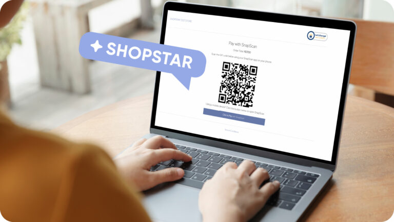 A woman sitting at her laptop viewing the SnapScan payment screen on a Shopstar website