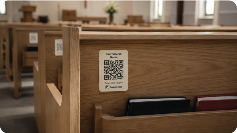 An image of a church pew with the SnapScan QR code (a cashless way to give) stuck to the back